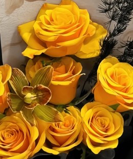 Close-up of golden roses and dark textural accents in the Lighthouse bouquet.